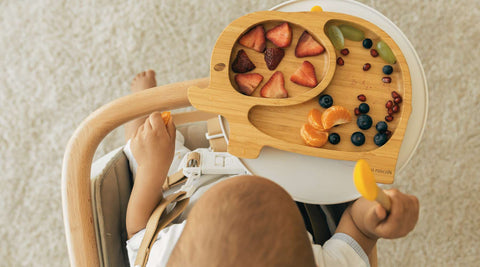 Children eating a lollipop together on a chair