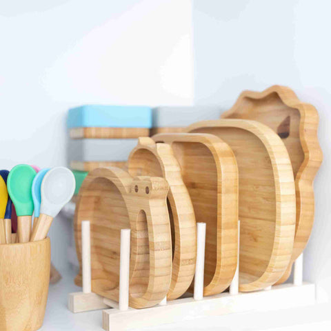 Bamboo plates in a rack, bamboo cup and spoons and bamboo snack pots 