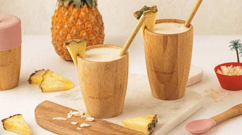 Pina Colada Mockatail in eco rascals bamboo cup with a pineapple behind it.