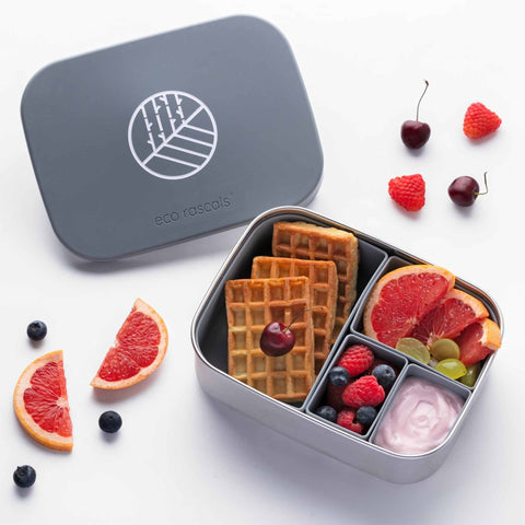 Image shows the classic silver lunchbox by eco rascals with food in each of the four removable dividers. The food shows is waffles, grapefruit, yoghurt and berries. 