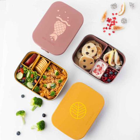 Image shows the mermaid lunchbox by eco rascals  with food inside. There is also the classic mustard lunchbox beside it. 