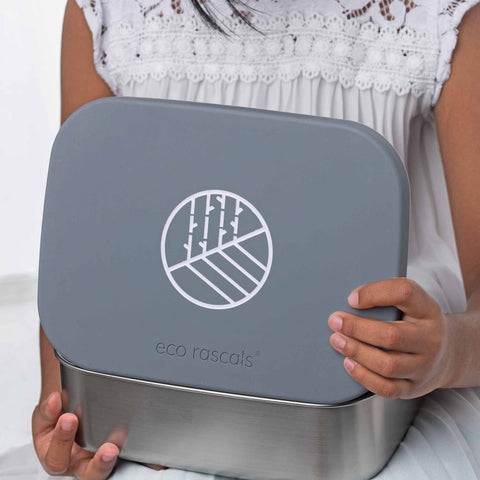 Image shows the classic silver lunchbox by eco rascals in the hands of a child. 